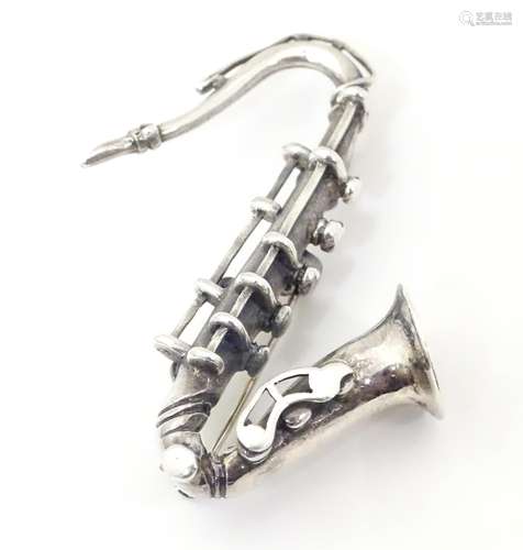 A silver brooch formed as a saxophone. Approx 2