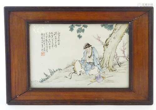 A Chinese porcelain plaque decorated with a seated