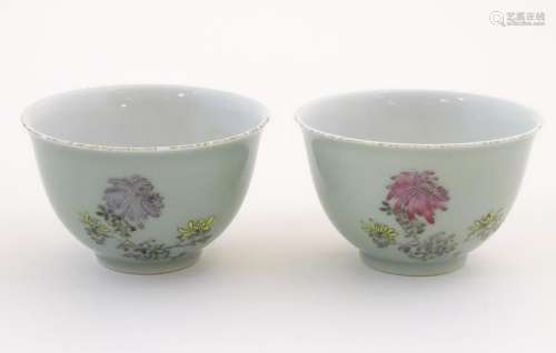 A pair of Chinese tea bowls decorated with flowers and
