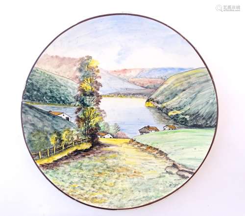 A Portuguese hand painted charger depicting a landscape