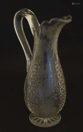 A cut glass jug / ewer with etched fruiting vine