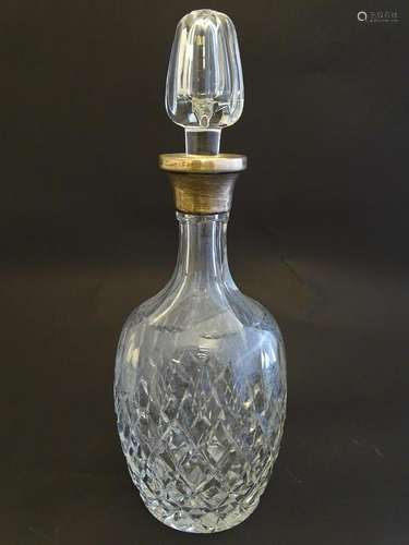 A cut glass decanter with silver collar hallmarked