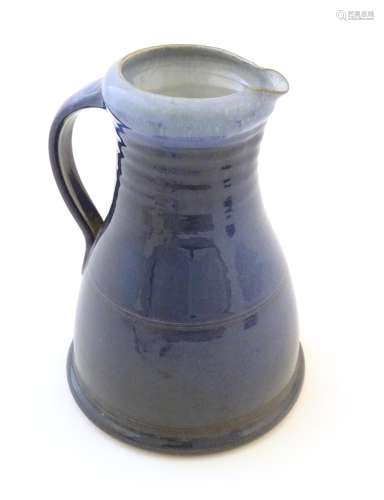A studio pottery jug with a blue glaze, ribbed neck and