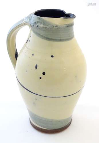 A studio pottery jug with drip and brushwork