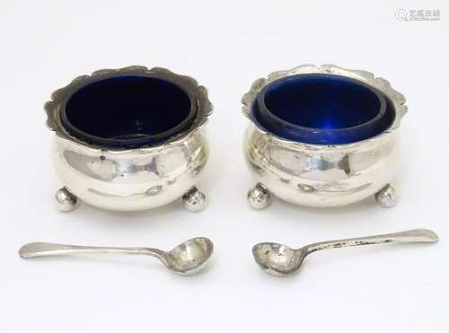 A pair of silver salts with blue glass liners and