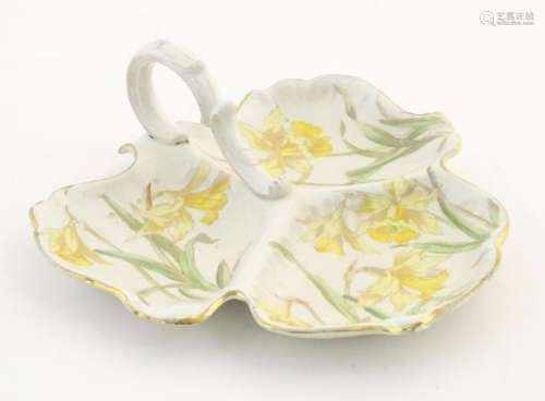 A three sectional leaf shaped plate with central handle