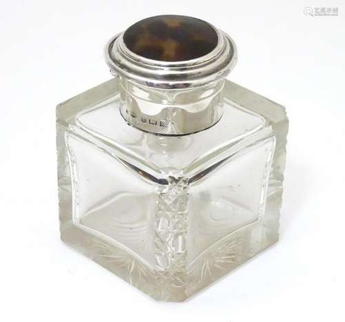 A cut glass inkwell with silver mounts and tortoise