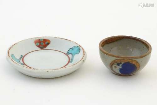 A small saucer with naive hand painted decoration,