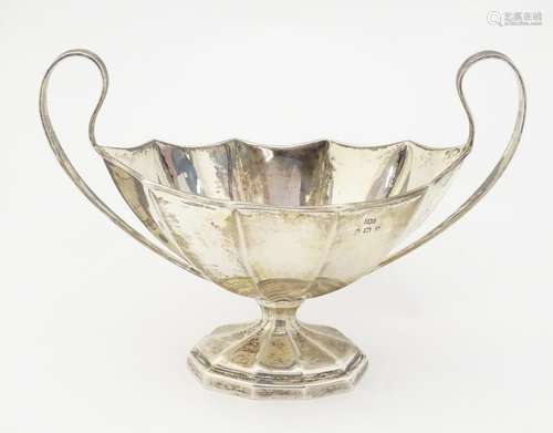 A silver sugar bowl of pedestal form with twin handles,