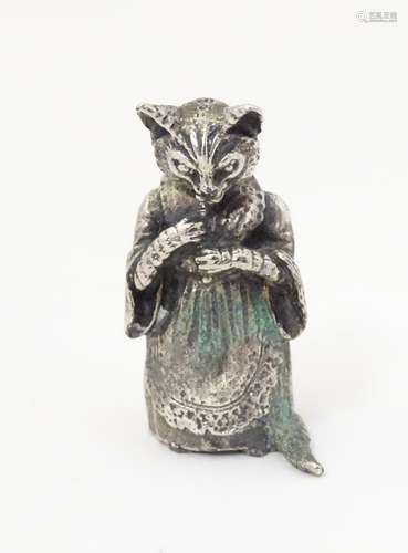 A white metal model of a Beatrix Potter style cat.