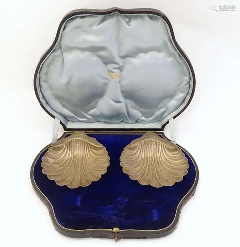 A pair of silver butter dishes of scallop shell form,