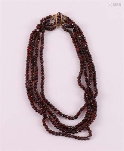 A four-row necklace with faceted garnets on a 14 kt gold cla...