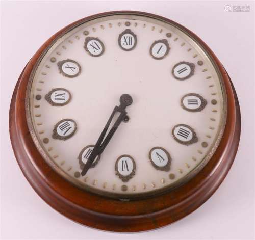A round wall clock in walnut casing, early 20th century.