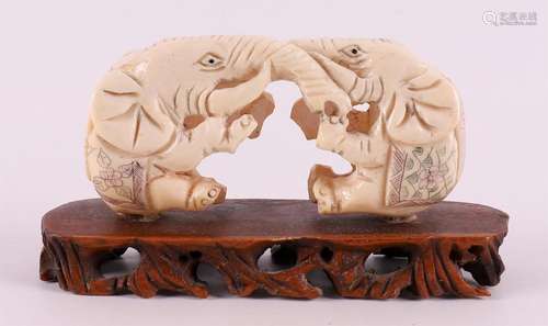 A pair of bone elephants on a wooden base, China, late 20th ...