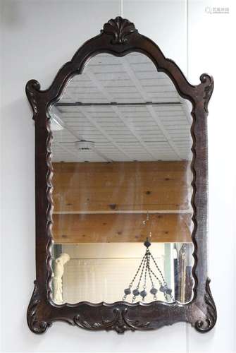 A mirror with a crown of leaf ornament and flora, around 190...