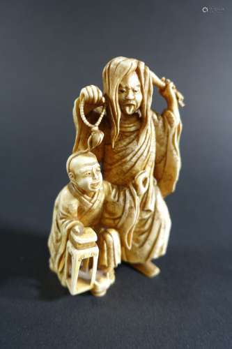JAPON : Okimono en ivoire teinté représentant un moine brand...