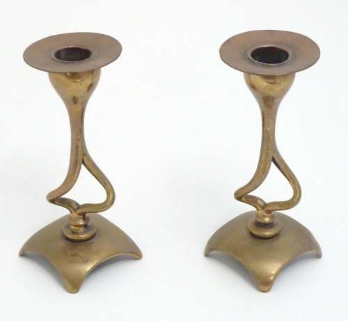 A pair of Art Nouveau brass and copper candlesticks with sin...