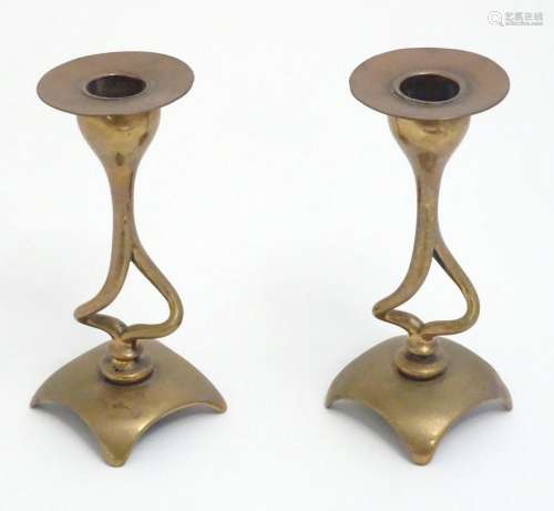 A pair of Art Nouveau brass and copper candlesticks with sin...