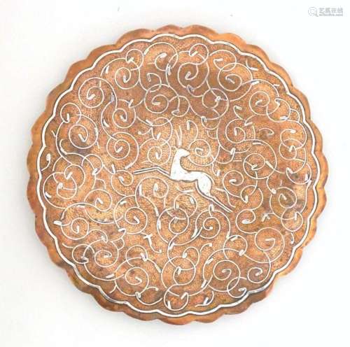 An early 20thC copper dish with a scalloped rim, punch detai...