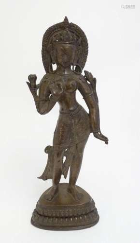 An Indian cast bronze model of a standing deity figure, with...