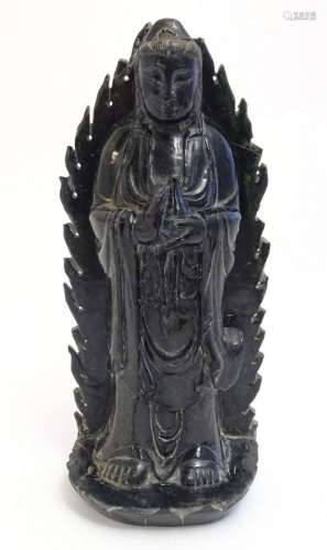 A Chinese nephrite figure modelled as Guanyin holding a bott...