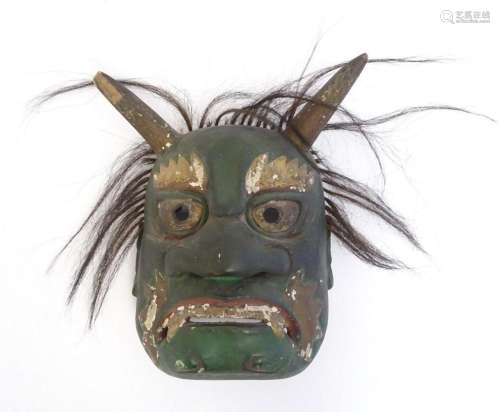 A Japanese carved Midori Oni mask with hair and traces of po...