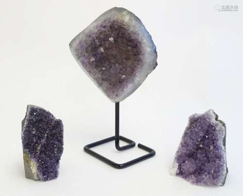 Three amethyst crystal geodes, one with polished edges and a...