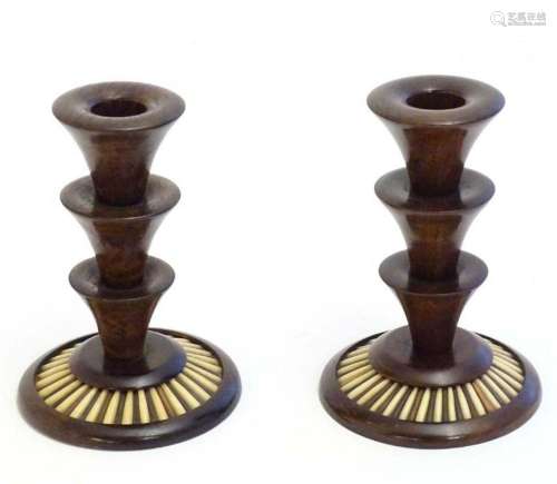 A pair of 20thC treen candlesticks with stepped columns and ...
