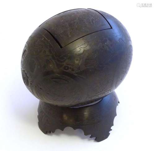 A 19thC carved coconut shell with stand and rectangular lid,...