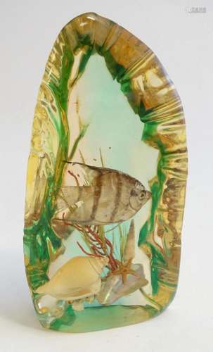 A 20thC lucite desk paperweight with underwater scene within...