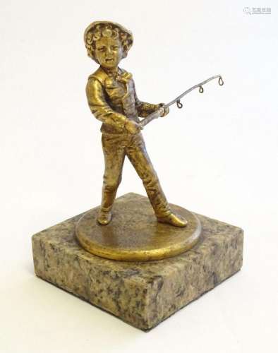 A 20thC cast model of a young boy holding a fishing rod on a...