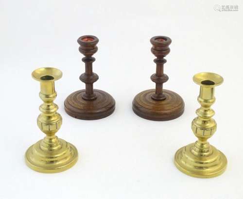 A pair of brass candlesticks with plunger action. Together w...