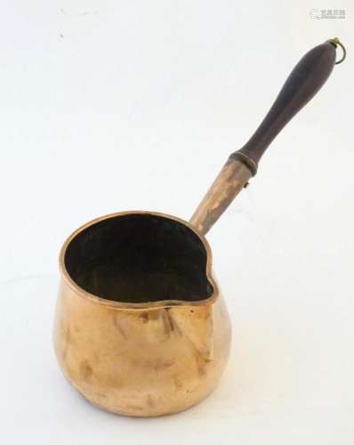 A 19thC copper saucepan with spout and turned wooden handle....