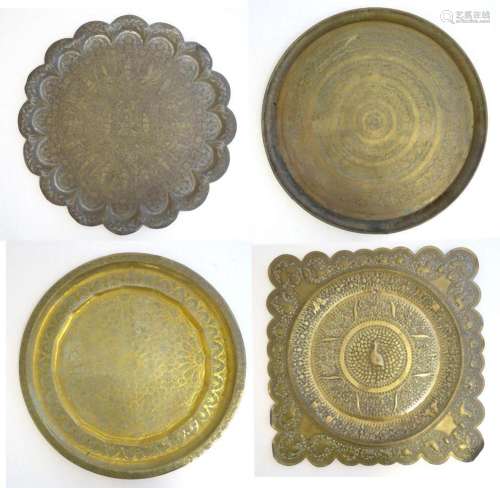 Four assorted Eastern brass trays / table tops, each with in...