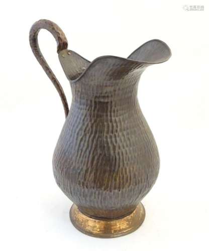 A large 20thC copper jug / pitcher with hammered decoration....