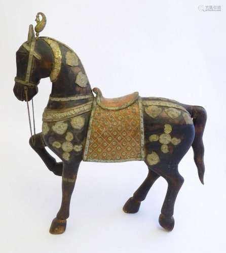 A 20thC carved hardwood standing horse with one leg raised, ...