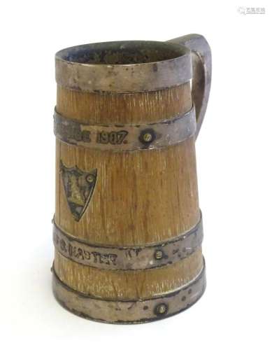 An oak tankard with silver plate handle, banding and shield,...