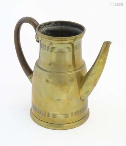 An early 20thC Continental brass jug, with curved hardwood h...