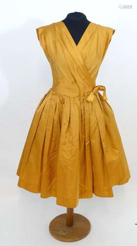 Vintage c A c1950's dress in orange, with full skirt an...