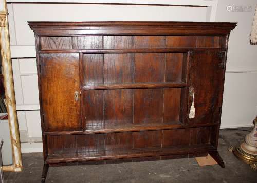 An antique oak dresser rack, shelved and boarded, flanked by...