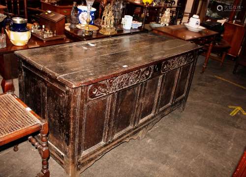 A large 18th Century oak coffer, with carved frieze above fi...