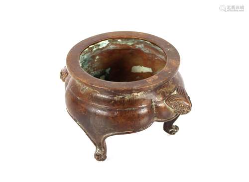 A Chinese bronze censer, having masked decoration and raised...