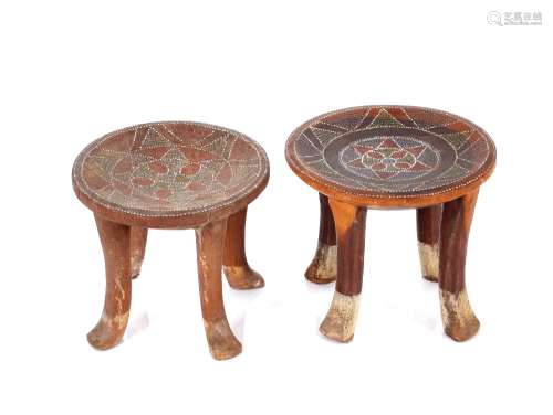 A pair of wooden ethnic four legged stools, with dished tops...