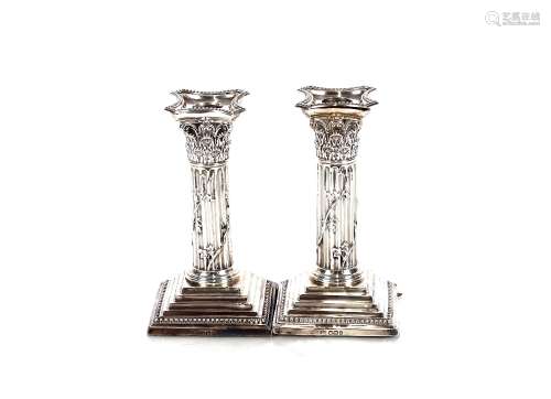 A pair of late Victorian silver Corinthian column candlestic...