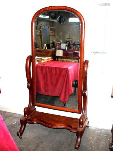 A Victorian mahogany cheval mirror, raised on scrolled arms ...