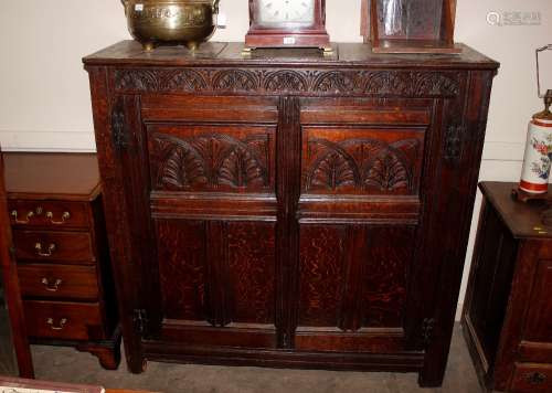 An 18th Century carved oak storage cupboard, the interior sh...