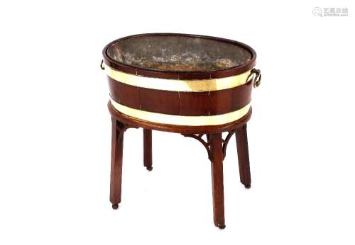 A George III mahogany oval wine cooler, brass banded and rai...