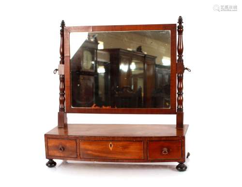 A Georgian mahogany bow fronted swing toilet mirror, on thre...
