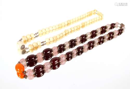 An antique ivory necklace; various stones; and an amber colo...
