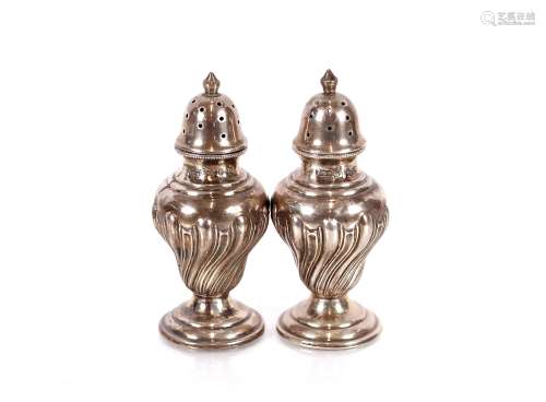 A pair of Victorian silver baluster pepperettes, having flut...